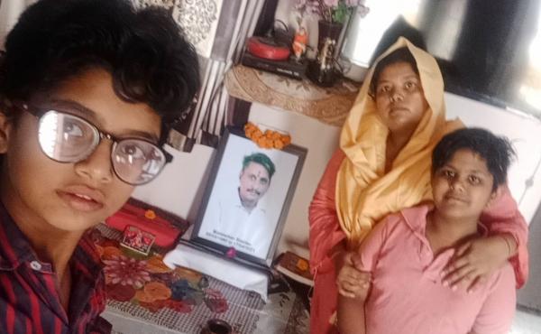 Pooja Sharma, center, and her two daughters, Lata, 14, and Yukti, 12. They sit in front of a portrait of Sharma's late husband and the girls' father, Manmohan. He died from COVID in April, leaving Sharma to fend for her family herself. Pooja Sharma, center, and her two daughters, Lata, 14, and Yukti, 12. They sit in front of a portrait of Sharma's late husband and the girls' father, Manmohan. He died from COVID in April, leaving Sharma to fend for her family herself.