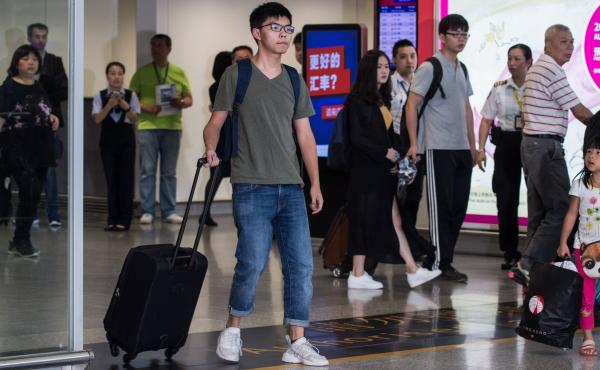 Pro-democracy activist Joshua Wong (center) arrives back in Hong Kong after being turned away from entering Bangkok by immigration officials and police. Pro-democracy activist Joshua Wong (center) arrives back in Hong Kong after being turned away from entering Bangkok by immigration officials and police.