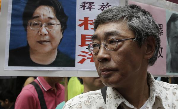 Freed Hong Kong bookseller Lam Wing-kee stands next to a placard with a picture of bookseller Gui Minhai, in front of his book store in Hong Kong in June 2016. Freed Hong Kong bookseller Lam Wing-kee stands next to a placard with a picture of bookseller Gui Minhai, in front of his book store in Hong Kong in June 2016.