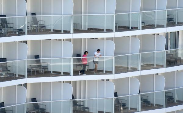 Passengers look out from the Spectrum of the Seas cruise ship docked in Hong Kong on Wednesday. Thousands of passengers were being held on the ship for coronavirus testing after health authorities said nine passengers were linked to a recent omicron clust Passengers look out from the Spectrum of the Seas cruise ship docked in Hong Kong on Wednesday. Thousands of passengers were being held on the ship for coronavirus testing after health authorities said nine passengers were linked to a recent omicron clust