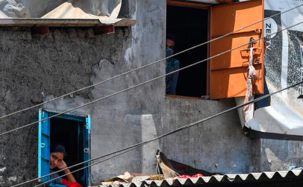Residents look out of their windows at the Dharavi slum during a government-imposed nationwide lockdown. Residents look out of their windows at the Dharavi slum during a government-imposed nationwide lockdown.