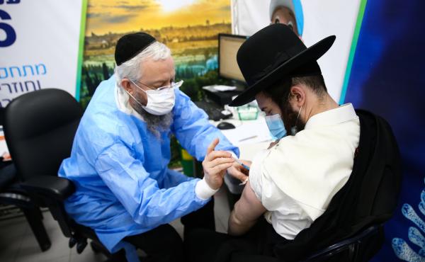 An Ultra-Orthodox Jewish man receives a dose of the Pfizer-BioNtech vaccine in the Israeli city of Bnei Brak in February. An Ultra-Orthodox Jewish man receives a dose of the Pfizer-BioNtech vaccine in the Israeli city of Bnei Brak in February.