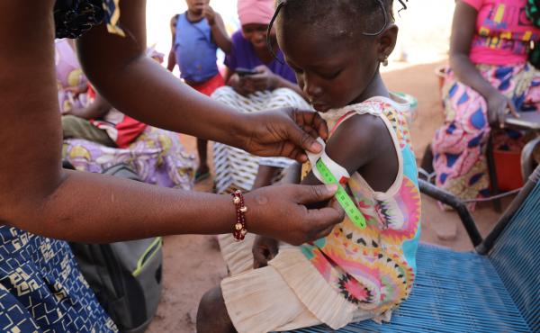 Nana Kadidia Diawara, a nurse who is a community health worker in Mali's capital city of Bamako, measures the arm of a child to check for signs of malnutrition. There's no charge for the care she provides. Nana Kadidia Diawara, a nurse who is a community health worker in Mali's capital city of Bamako, measures the arm of a child to check for signs of malnutrition. There's no charge for the care she provides.