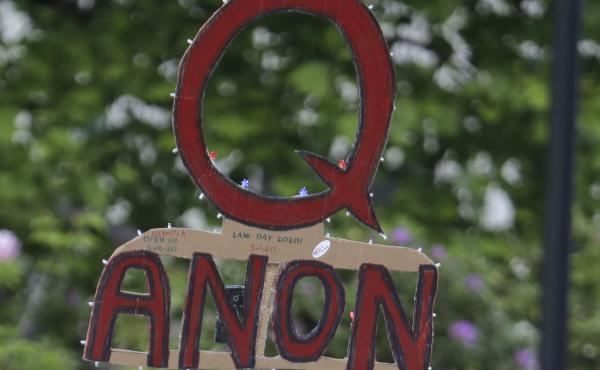 A person carries a sign supporting QAnon during a May 2020 protest rally in Olympia, Wash. A person carries a sign supporting QAnon during a May 2020 protest rally in Olympia, Wash.