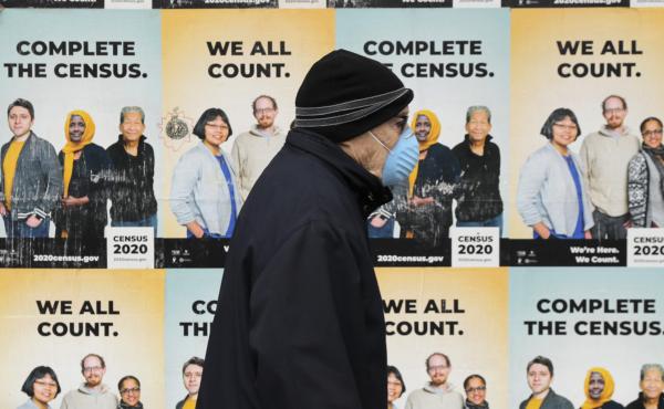 A person wearing a mask walks past posters encouraging census participation in Seattle in April 2020. The coronavirus pandemic has disrupted not only last year's national head count, but also a critical follow-up survey that the U.S. Census Bureau relies A person wearing a mask walks past posters encouraging census participation in Seattle in April 2020. The coronavirus pandemic has disrupted not only last year's national head count, but also a critical follow-up survey that the U.S. Census Bureau relies