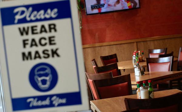 A sign asking patrons to wear a mask is seen at the entrance of a restaurant in New York City on Aug. 3. The spread of the delta variant led to sharply slower economic growth in the July-to-September quarter. A sign asking patrons to wear a mask is seen at the entrance of a restaurant in New York City on Aug. 3. The spread of the delta variant led to sharply slower economic growth in the July-to-September quarter.