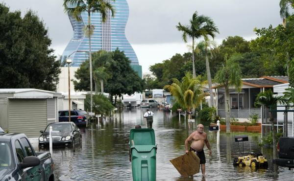 Residents clear debris from a flooded street in the Driftwood Acres Mobile Home Park, in the aftermath of Tropical Storm Eta, on Tuesday in Davie, Fla. Residents clear debris from a flooded street in the Driftwood Acres Mobile Home Park, in the aftermath of Tropical Storm Eta, on Tuesday in Davie, Fla.