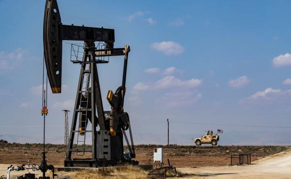 A U.S. military vehicle drives past an oil pump jack in the countryside of Syria's northeastern city of Qamishli. President Trump is leaving some U.S. troops in Syria, with the goal of controlling Syria's oil fields. But legal experts say exploiting the o A U.S. military vehicle drives past an oil pump jack in the countryside of Syria's northeastern city of Qamishli. President Trump is leaving some U.S. troops in Syria, with the goal of controlling Syria's oil fields. But legal experts say exploiting the o