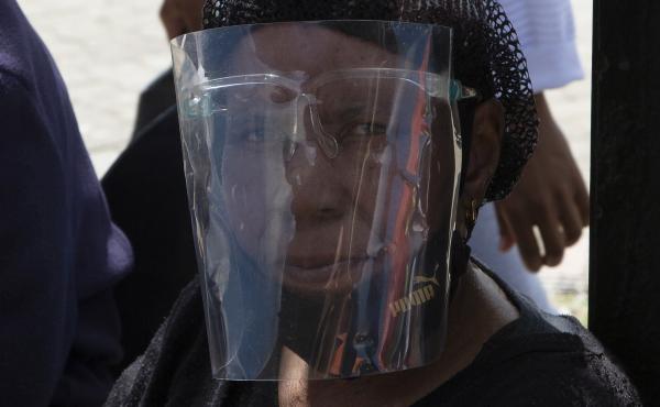 A woman wears a face shield to protect against COVID-19 at a taxi stand in Soweto, South Africa, where an omicron variant is causing a COVID-19 surge. A woman wears a face shield to protect against COVID-19 at a taxi stand in Soweto, South Africa, where an omicron variant is causing a COVID-19 surge.