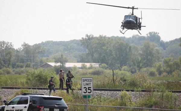 Police officers search an area around the Illinois city of Fox Lake, about 50 miles northwest of Chicago, for three suspects following the killing of a police officer early Tuesday. Police officers search an area around the Illinois city of Fox Lake, about 50 miles northwest of Chicago, for three suspects following the killing of a police officer early Tuesday.