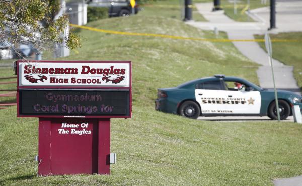 Law enforcement officers block off the entrance to Marjory Stoneman Douglas High School on Feb. 15 in Parkland, Fla. A day earlier a gunman opened fire in the school. Law enforcement officers block off the entrance to Marjory Stoneman Douglas High School on Feb. 15 in Parkland, Fla. A day earlier a gunman opened fire in the school.