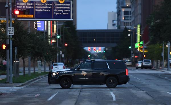 A police car patrols in downtown Houston on Wednesday following the first night of curfew after Harvey caused heavy flooding in the city. A police car patrols in downtown Houston on Wednesday following the first night of curfew after Harvey caused heavy flooding in the city.