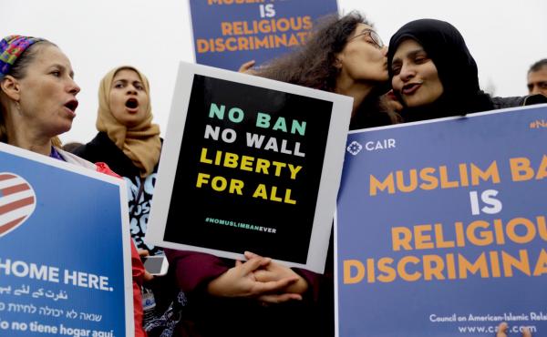 Deeba Jafri gives Hena Zuberi a kiss as they protest in front of Supreme Court on Wednesday as the court heard arguments over the Trump Administration's travel ban. Deeba Jafri gives Hena Zuberi a kiss as they protest in front of Supreme Court on Wednesday as the court heard arguments over the Trump Administration's travel ban.