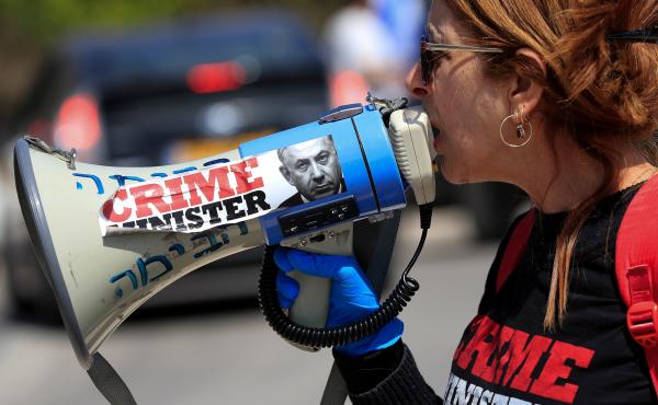 An anti-Netanyahu protester shouts slogans during a demonstration in front of the Knesset in Jerusalem on Wednesday. An anti-Netanyahu protester shouts slogans during a demonstration in front of the Knesset in Jerusalem on Wednesday.