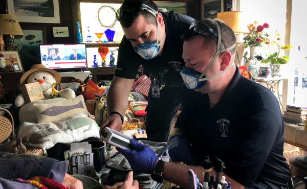 In between answering 911 calls, Jerrad Dinsmore (left) and Kevin LeCaptain perform a wellness check at the home of a woman in her nineties. The ambulance team in the small town of Waldoboro, Maine was already short-staffed. Then a team member quit recentl In between answering 911 calls, Jerrad Dinsmore (left) and Kevin LeCaptain perform a wellness check at the home of a woman in her nineties. The ambulance team in the small town of Waldoboro, Maine was already short-staffed. Then a team member quit recentl