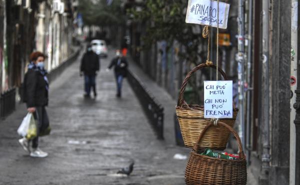 A solidarity basket with a note reading "Those who can, put something in, those who can't, help yourself" is hung in the historic center of Naples. A solidarity basket with a note reading "Those who can, put something in, those who can't, help yourself" is hung in the historic center of Naples.