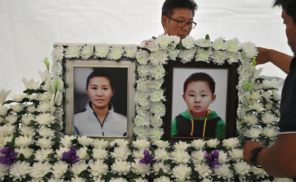 A man sets up portraits of North Korean defector Han Seong-ok and her 6-year-old son, who are believed to have died from starvation, at a makeshift shrine in downtown Seoul on Aug. 28. A man sets up portraits of North Korean defector Han Seong-ok and her 6-year-old son, who are believed to have died from starvation, at a makeshift shrine in downtown Seoul on Aug. 28.