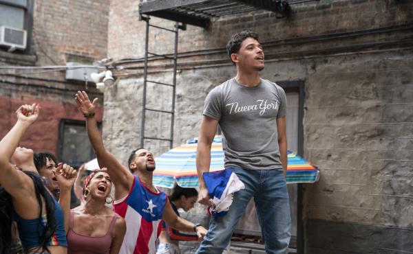 Usnavi (Anthony Ramos) runs a corner bodega and dreams of returning to the Dominican Republic in In the Heights. Usnavi (Anthony Ramos) runs a corner bodega and dreams of returning to the Dominican Republic in In the Heights.