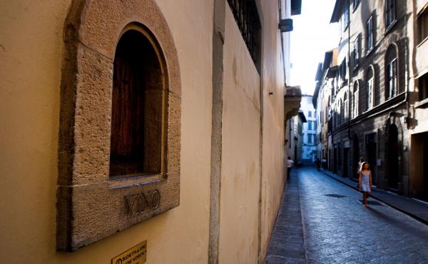 A girl walks past a buchetta del vino, a small window to serve wine, typical in Florence. A girl walks past a buchetta del vino, a small window to serve wine, typical in Florence.