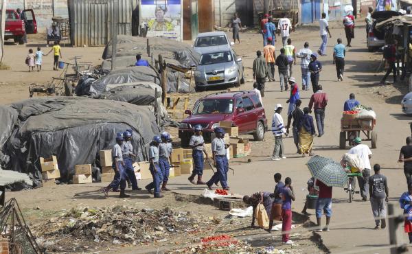 Zimbabwe riot police patrol the streets near a fruit and vegetable market in Harare on Thursday. Zimbabwe riot police patrol the streets near a fruit and vegetable market in Harare on Thursday.