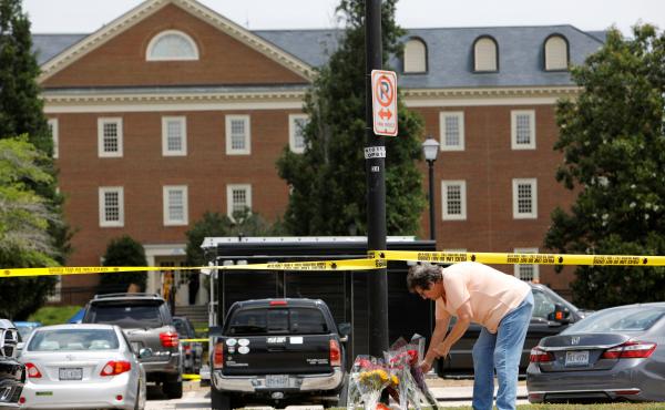 A resident places flowers at a memorial the day after the shootings deaths of 12 people in Virginia Beach, Va. A resident places flowers at a memorial the day after the shootings deaths of 12 people in Virginia Beach, Va.