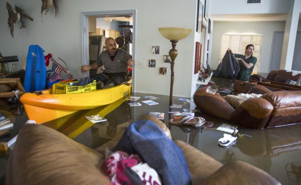 Larry Koser Jr. (left) and his son, Matthew, look for important papers and heirlooms inside his house after it was flooded by heavy rains from Hurricane Harvey. Larry Koser Jr. (left) and his son, Matthew, look for important papers and heirlooms inside his house after it was flooded by heavy rains from Hurricane Harvey.