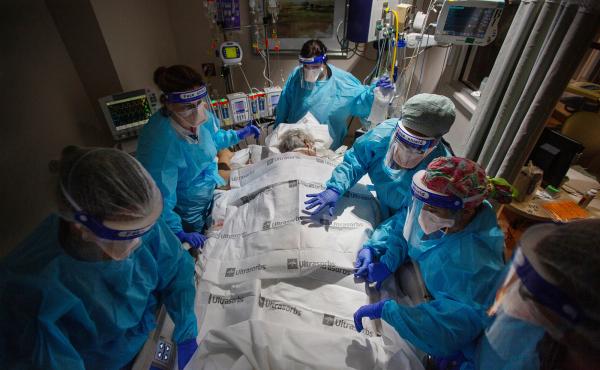 A team of nurses, patient care technicians and a respiratory therapist prepare to return a COVID patient to their back after 24 hours of lying on their stomach. That posture makes it easier to breathe and is a critical part of treatment for COVID patients A team of nurses, patient care technicians and a respiratory therapist prepare to return a COVID patient to their back after 24 hours of lying on their stomach. That posture makes it easier to breathe and is a critical part of treatment for COVID patients