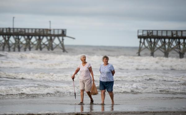 Mary McCants (left) and Amy Garrett walk near a damaged pier the morning after Hurricane Isaias came through late Monday night in North Myrtle Beach, S.C. Hurricane Isaias was downgraded to a tropical storm on Tuesday after making landfall overnight as a Mary McCants (left) and Amy Garrett walk near a damaged pier the morning after Hurricane Isaias came through late Monday night in North Myrtle Beach, S.C. Hurricane Isaias was downgraded to a tropical storm on Tuesday after making landfall overnight as a
