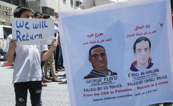 Palestinians lift banners protesting the killing of Eyad Hallaq, a Palestinian man with autism shot dead by Israeli police, and the case of George Floyd, an unarmed black man killed by policeman in the U.S., during a rally by supporters of the Fatah movem Palestinians lift banners protesting the killing of Eyad Hallaq, a Palestinian man with autism shot dead by Israeli police, and the case of George Floyd, an unarmed black man killed by policeman in the U.S., during a rally by supporters of the Fatah movem