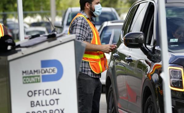 An election worker takes ballots from voters dropping them off at an official ballot drop box this week at the Miami-Dade County Board of Elections in Doral, Fla. An election worker takes ballots from voters dropping them off at an official ballot drop box this week at the Miami-Dade County Board of Elections in Doral, Fla.
