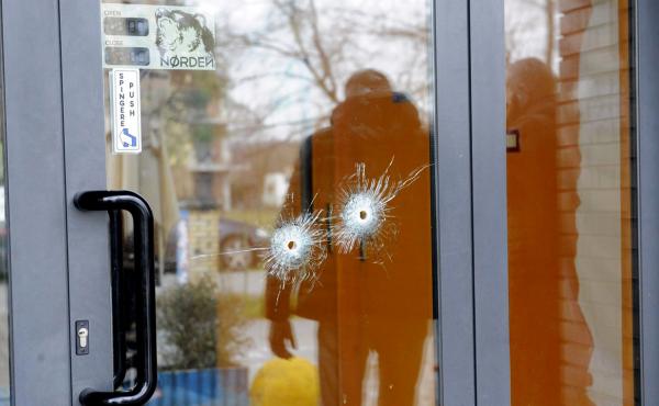 Bullet holes are seen in a glass door as police forensics officers carry out investigations in the area following the wounding of several foreign nationals in a drive-by shooting in Macerata. Bullet holes are seen in a glass door as police forensics officers carry out investigations in the area following the wounding of several foreign nationals in a drive-by shooting in Macerata.