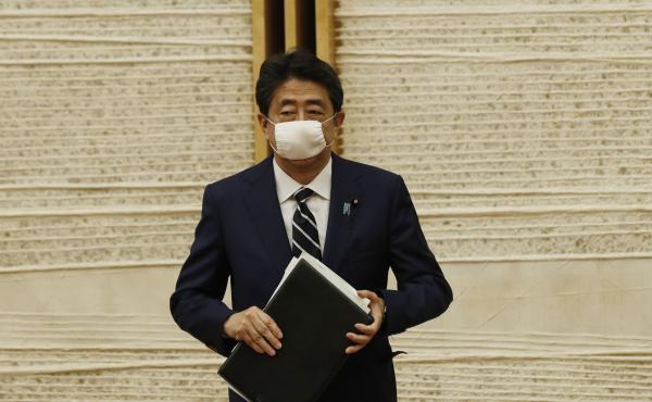 Japanese Prime Minister Shinzo Abe leaves a news conference Monday in Tokyo, after lifting the country's nationwide state of emergency over the coronavirus. Japanese Prime Minister Shinzo Abe leaves a news conference Monday in Tokyo, after lifting the country's nationwide state of emergency over the coronavirus.