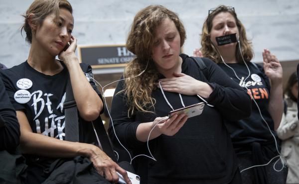 Protesters rallying against Kavanaugh watch testimony from Ford on a smartphone inside the Hart Senate Office Building in Washington, D.C. Protesters rallying against Kavanaugh watch testimony from Ford on a smartphone inside the Hart Senate Office Building in Washington, D.C.