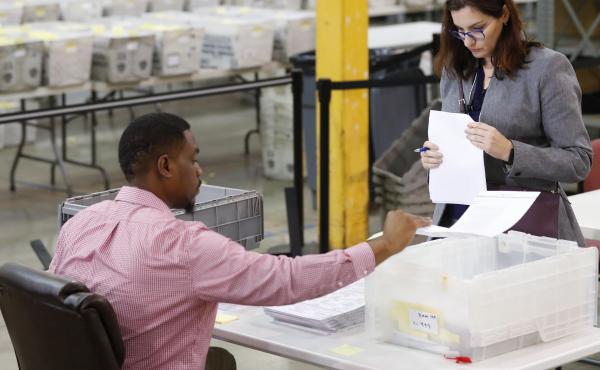 A Republican party observer, right, watches as an employee at the Palm Beach County Supervisor Of Elections office goes through a stack of damaged ballots, Thursday, Nov. 15, 2018, in West Palm Beach, Fla. A Republican party observer, right, watches as an employee at the Palm Beach County Supervisor Of Elections office goes through a stack of damaged ballots, Thursday, Nov. 15, 2018, in West Palm Beach, Fla.