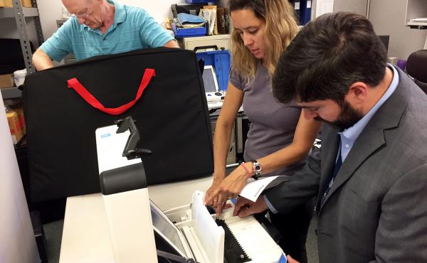 From left, Bill Wanlund of the Falls Church electoral board, Jessica Wilson of voting machine company Hart InterCivic and David Bjerke, the Falls Church director of elections test the city's new voting machines ahead of this November's election. From left, Bill Wanlund of the Falls Church electoral board, Jessica Wilson of voting machine company Hart InterCivic and David Bjerke, the Falls Church director of elections test the city's new voting machines ahead of this November's election.