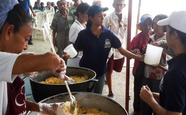 Men, women and children line up for free lunch at a soup kitchen in Maracaibo, Venezuela. The meal consists of a bottle of milk and a few scoops of rice mixed with eggs and vegetables. Men, women and children line up for free lunch at a soup kitchen in Maracaibo, Venezuela. The meal consists of a bottle of milk and a few scoops of rice mixed with eggs and vegetables.