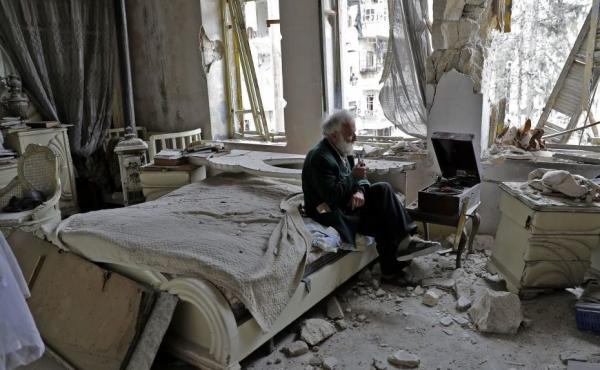 Mohammed Mohiedin Anis, or Abu Omar, 70, smokes his pipe as he sits in his destroyed bedroom listening to music on his vinyl player, gramophone, in Aleppo's formerly rebel-held al-Shaar neighbourhood. Mohammed Mohiedin Anis, or Abu Omar, 70, smokes his pipe as he sits in his destroyed bedroom listening to music on his vinyl player, gramophone, in Aleppo's formerly rebel-held al-Shaar neighbourhood.