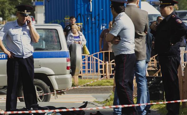 Police officers stand by the body of a man who was killed after an alleged stabbing attack on Saturday in the Siberian city of Surgut, Russia. Police officers stand by the body of a man who was killed after an alleged stabbing attack on Saturday in the Siberian city of Surgut, Russia.