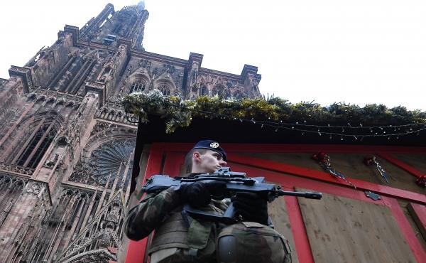A French soldier stands guard at the Christmas market in Strasbourg, in front of the city's cathedral, as police conduct a search for a man suspected of opening fire on a crowd the night before. A French soldier stands guard at the Christmas market in Strasbourg, in front of the city's cathedral, as police conduct a search for a man suspected of opening fire on a crowd the night before.