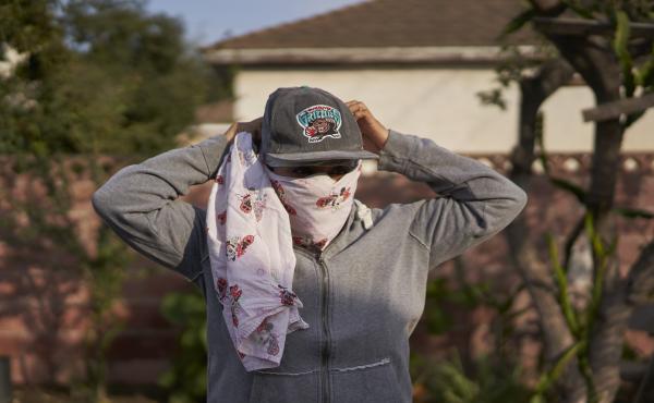 Gabriela, 32, a strawberry picker from Oaxaca, Mexico, who lives in Oxnard, Calif., had to wear a bandanna to cover her nose and mouth to avoid inhaling smoke from a wildfire while working in the fields. Gabriela, 32, a strawberry picker from Oaxaca, Mexico, who lives in Oxnard, Calif., had to wear a bandanna to cover her nose and mouth to avoid inhaling smoke from a wildfire while working in the fields.
