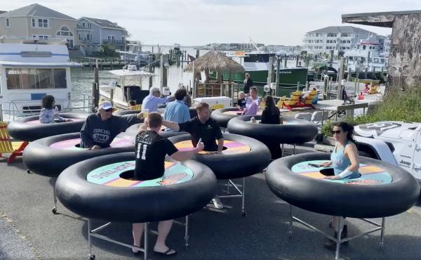 Fish Tales Bar & Grill, a restaurant in Ocean City, Md., tries out "bumper tables." Designed by an event production company, they're meant to allow diners to practice social distancing. Fish Tales Bar & Grill, a restaurant in Ocean City, Md., tries out "bumper tables." Designed by an event production company, they're meant to allow diners to practice social distancing.