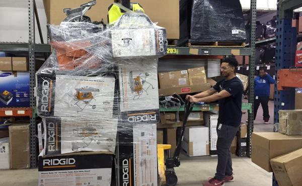 An employee drags a palette of recently returned goods through the Optoro warehouse so they can be processed. An employee drags a palette of recently returned goods through the Optoro warehouse so they can be processed.