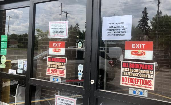 A sign on the front doors of Westlund's Apple Market in Lansing, Mich., asks customers to wear a mask unless they are vaccinated against COVID-19. A sign on the front doors of Westlund's Apple Market in Lansing, Mich., asks customers to wear a mask unless they are vaccinated against COVID-19.
