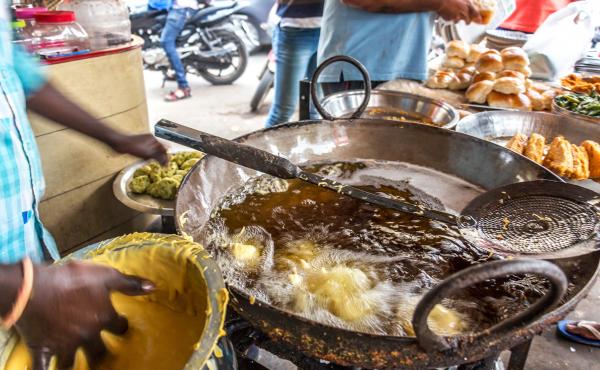 A street vendor frying potato vadas for vada pav in Mumbai's busy Dadar neighborhood. A street vendor frying potato vadas for vada pav in Mumbai's busy Dadar neighborhood.