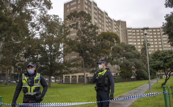 Police guard access to housing commission apartments under lockdown in Melbourne, Australia. The hard-hit Australian state of Victoria recorded two deaths and its highest-ever daily increase in coronavirus cases on Monday as authorities prepare to close i Police guard access to housing commission apartments under lockdown in Melbourne, Australia. The hard-hit Australian state of Victoria recorded two deaths and its highest-ever daily increase in coronavirus cases on Monday as authorities prepare to close i