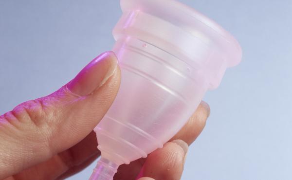 A menstrual cup — this one is made of silicone rubber — is designed to collect menstrual blood. The bell-shaped device is folded and inserted into the vagina. The tip helps with removal. A menstrual cup — this one is made of silicone rubber — is designed to collect menstrual blood. The bell-shaped device is folded and inserted into the vagina. The tip helps with removal.