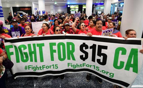 Airport employees, Uber and Lyft drivers, and other workers protest for a $15 minimum wage at Los Angeles International Airport in October. Increases in minimum wages contributed to bigger pay gains for lower-income workers. Airport employees, Uber and Lyft drivers, and other workers protest for a $15 minimum wage at Los Angeles International Airport in October. Increases in minimum wages contributed to bigger pay gains for lower-income workers.