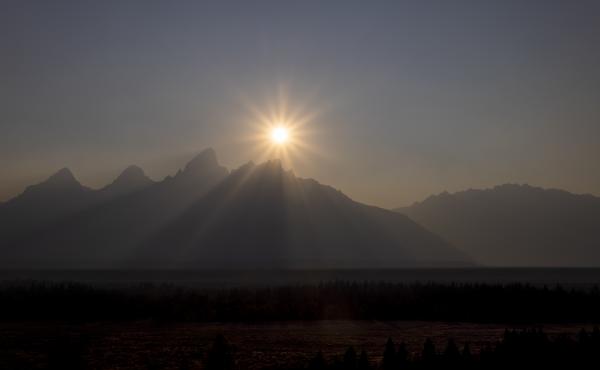 A peak is shrouded in smoke from regional wildfires on July 14, at Grand Teton National Park, south of Yellowstone. A peak is shrouded in smoke from regional wildfires on July 14, at Grand Teton National Park, south of Yellowstone.