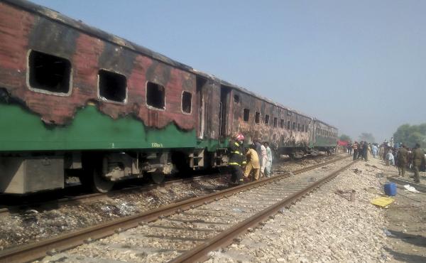 Pakistani officials examine a train damaged by a fire in Liaquatpur, Pakistan, on Thursday. A massive fire engulfed three carriages of the train traveling in the country's eastern Punjab province. Pakistani officials examine a train damaged by a fire in Liaquatpur, Pakistan, on Thursday. A massive fire engulfed three carriages of the train traveling in the country's eastern Punjab province.