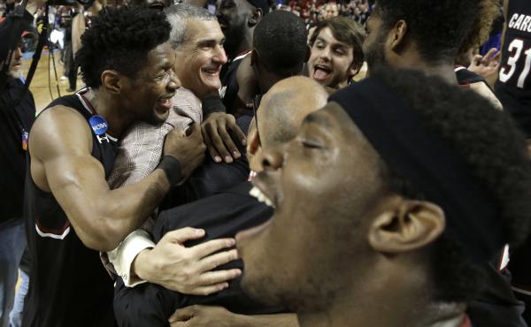 South Carolina head coach Frank Martin, second from left, is hugged by Chris Silva, left, as they celebrate after a second-round game against Duke in the NCAA men's college basketball tournament in Greenville, S.C., on Sunday. South Carolina head coach Frank Martin, second from left, is hugged by Chris Silva, left, as they celebrate after a second-round game against Duke in the NCAA men's college basketball tournament in Greenville, S.C., on Sunday.